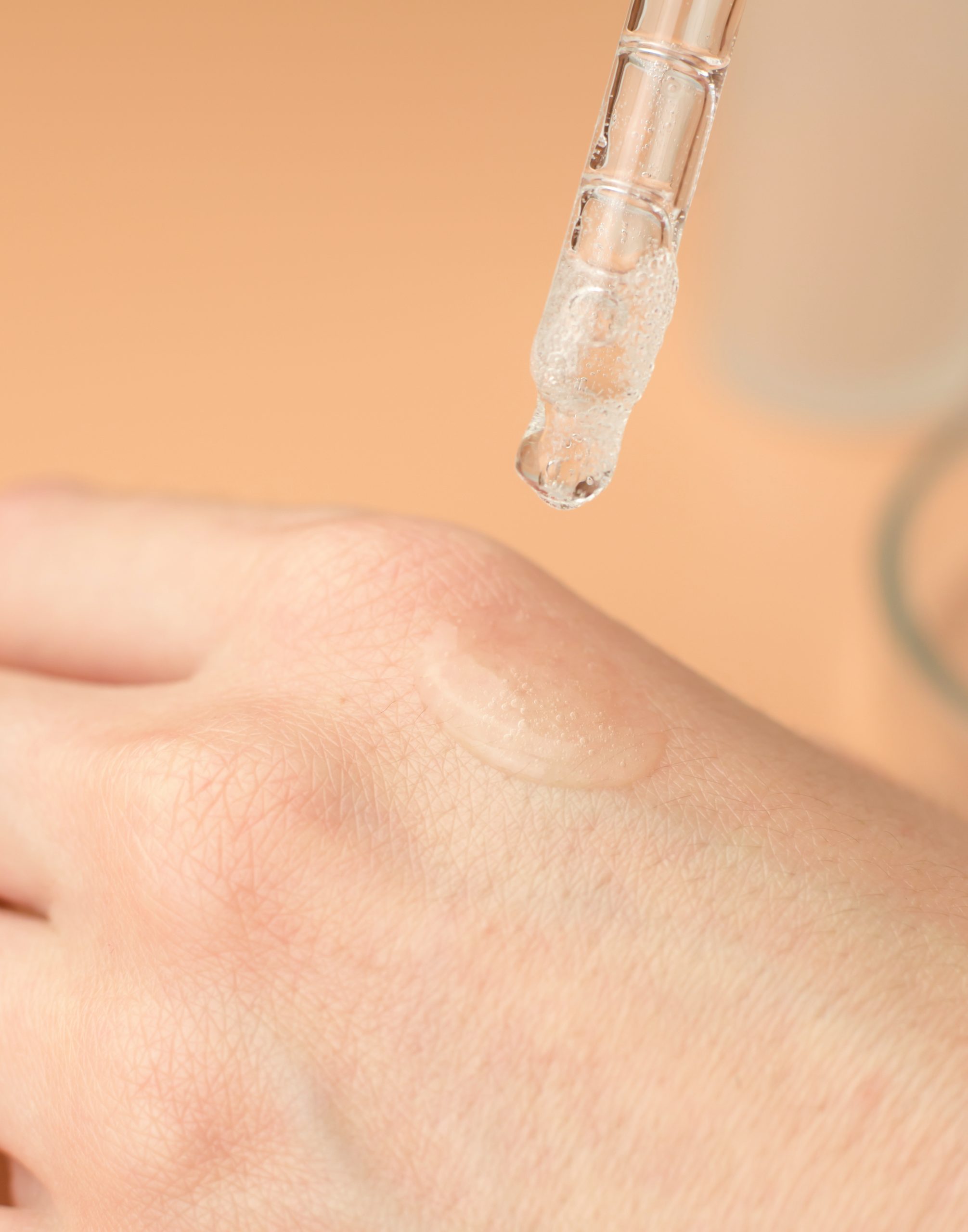 Transparent gel on a female hand. A woman applies a moisturizing gel with a pipette on her wrist.
