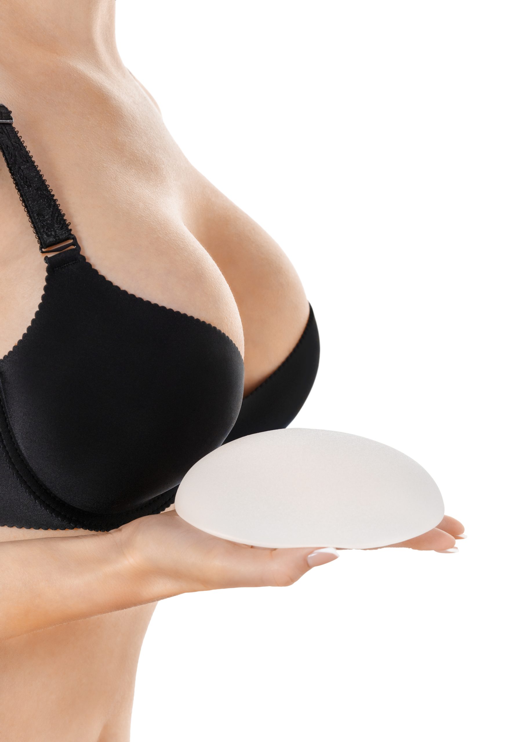Woman holding implant in hand on white background. Breast augmentation.