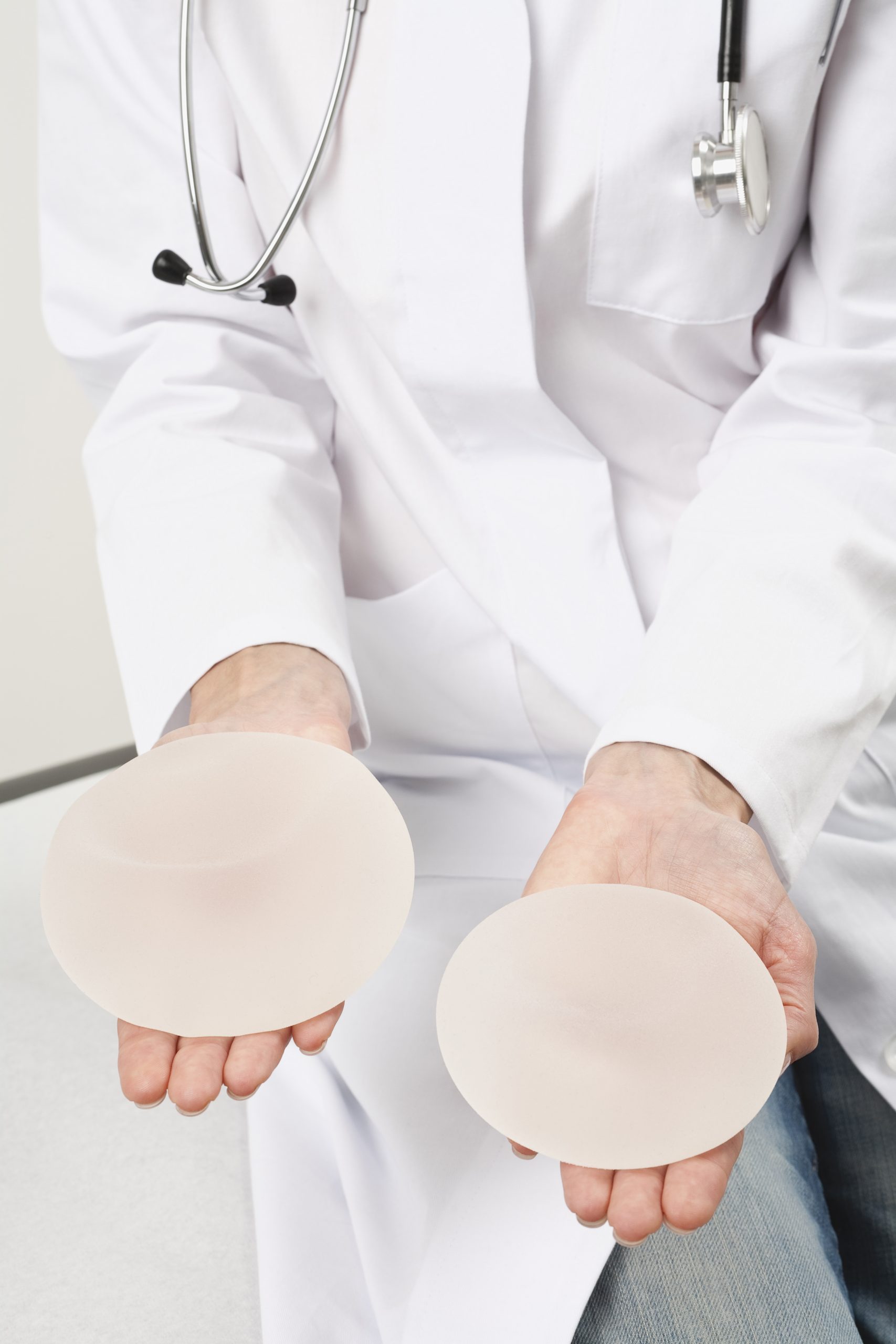 Germany, Munich, Doctor holding breast implant, close up